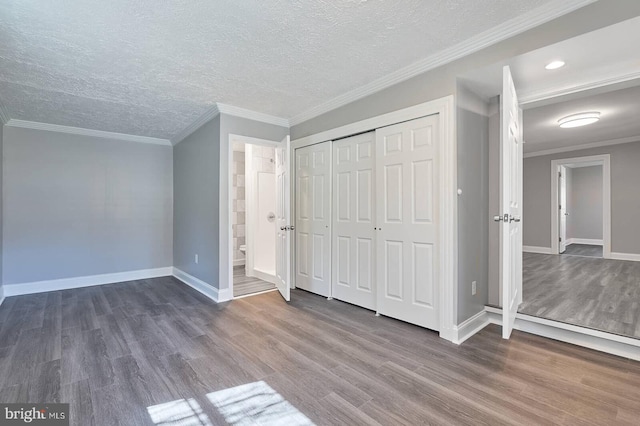 unfurnished bedroom featuring ornamental molding, baseboards, and wood finished floors