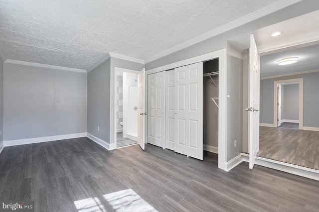 unfurnished bedroom with baseboards, a textured ceiling, dark wood-style floors, and crown molding