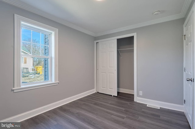 unfurnished bedroom with visible vents, baseboards, dark wood-style flooring, and ornamental molding