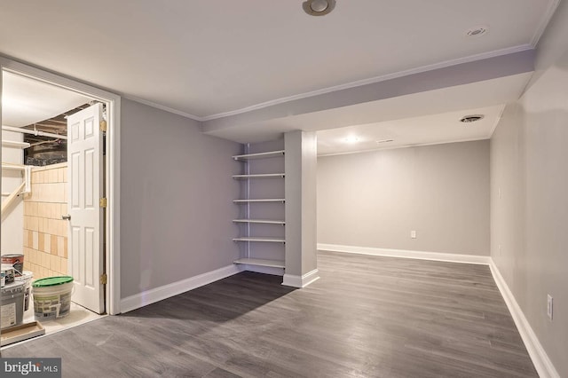 finished below grade area featuring crown molding, wood finished floors, and baseboards