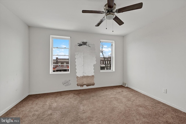 empty room featuring visible vents, baseboards, carpet, and a ceiling fan