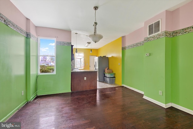 empty room with visible vents, baseboards, ceiling fan, and hardwood / wood-style floors