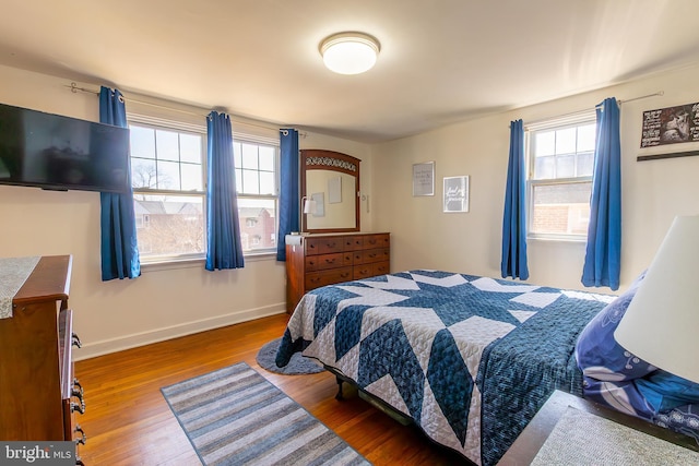 bedroom featuring baseboards and wood finished floors