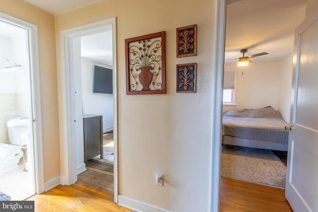 corridor with wood finished floors and baseboards