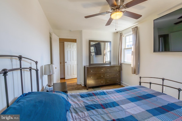 bedroom featuring a ceiling fan, baseboards, and wood finished floors