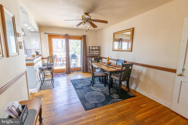 dining space with wood finished floors, baseboards, and ceiling fan