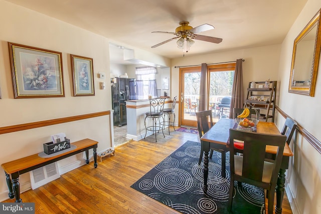 dining room with visible vents, a ceiling fan, light wood-type flooring, and baseboards