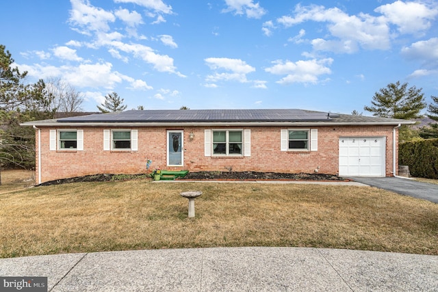 ranch-style home featuring brick siding, aphalt driveway, an attached garage, and a front lawn