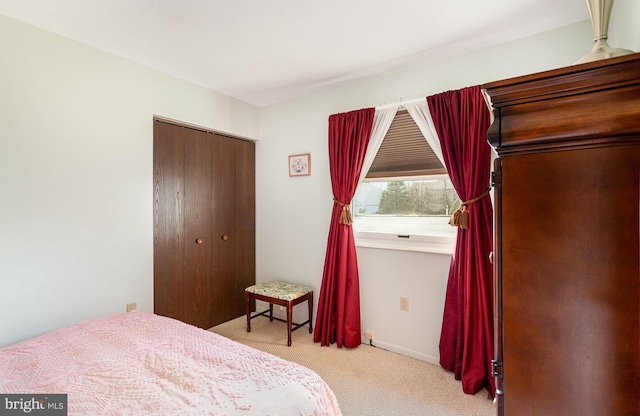 bedroom with baseboards, a closet, and carpet floors