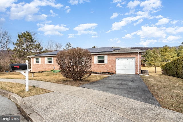 ranch-style house featuring brick siding, driveway, a front lawn, and a garage