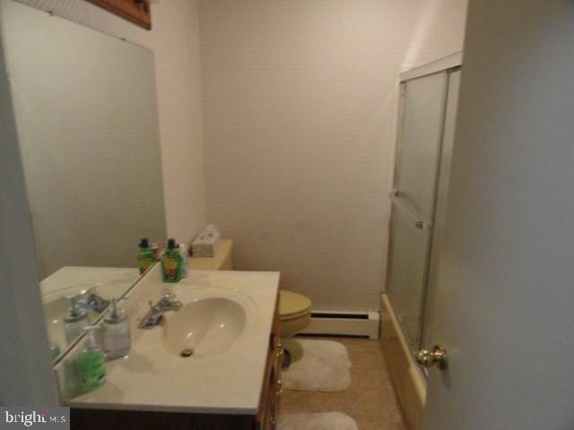 bathroom featuring an enclosed shower, toilet, vanity, and a baseboard heating unit