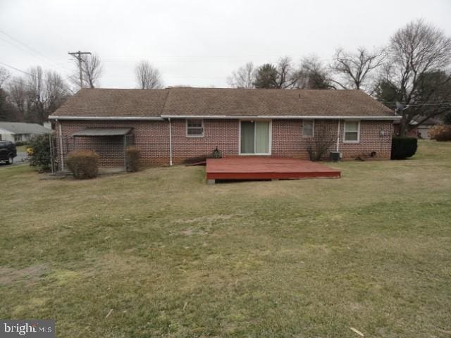 back of house with a deck, a yard, and brick siding