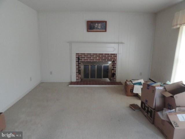 carpeted living room with a brick fireplace