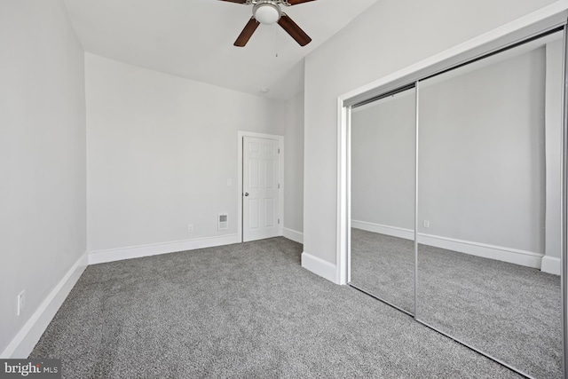 unfurnished bedroom featuring baseboards, a closet, carpet floors, and ceiling fan