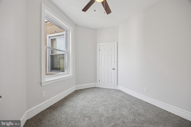 carpeted empty room featuring baseboards and ceiling fan