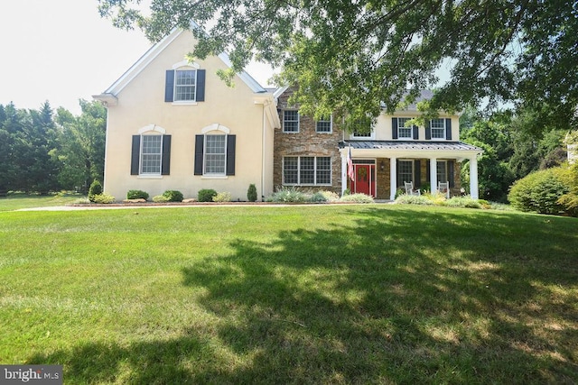 view of front facade featuring stucco siding, stone siding, and a front yard