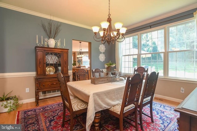 dining area featuring a notable chandelier, wood finished floors, baseboards, and ornamental molding