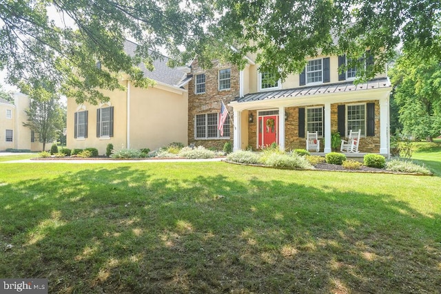 view of front of house featuring stone siding, stucco siding, a porch, and a front yard