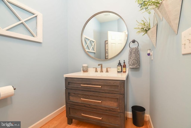 bathroom featuring vanity, wood finished floors, and baseboards