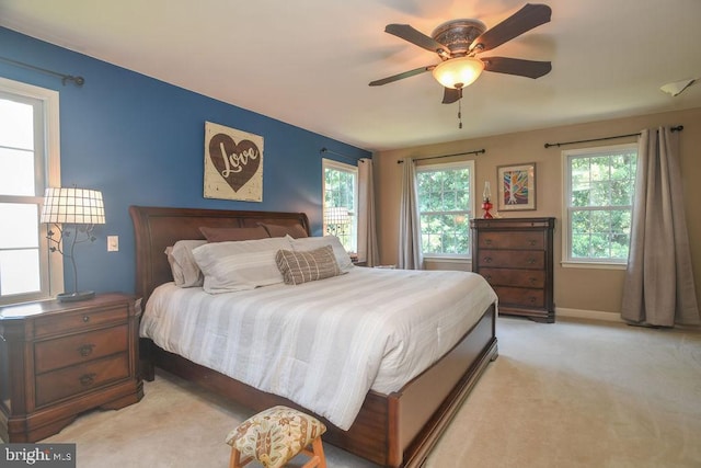 bedroom featuring light carpet, ceiling fan, and baseboards