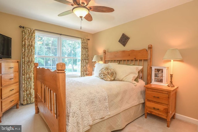 bedroom with baseboards, light colored carpet, and a ceiling fan