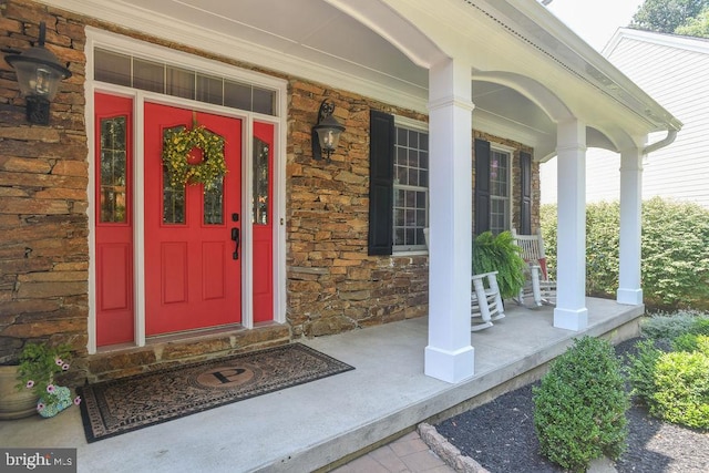 property entrance with stone siding and covered porch