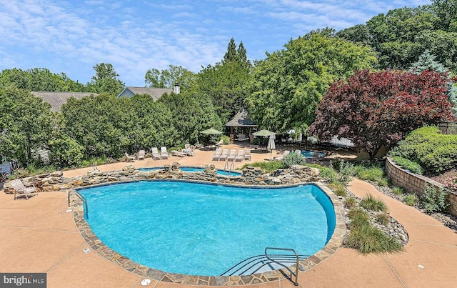 pool with a gazebo and a patio area