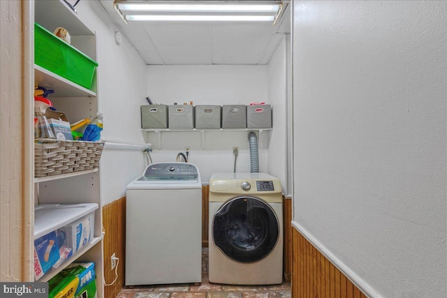 washroom with wainscoting and washer and dryer