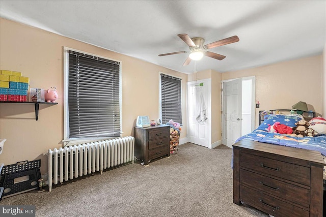 carpeted bedroom featuring radiator, baseboards, and ceiling fan