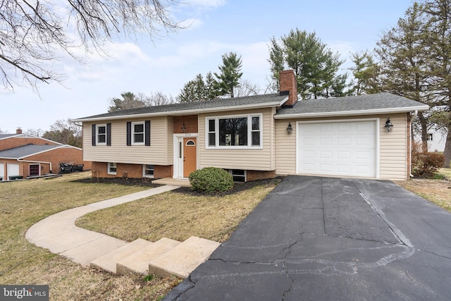 raised ranch with aphalt driveway, a garage, a front yard, and a chimney