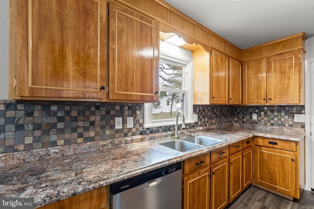 kitchen with backsplash, dark wood finished floors, dishwasher, brown cabinets, and a sink