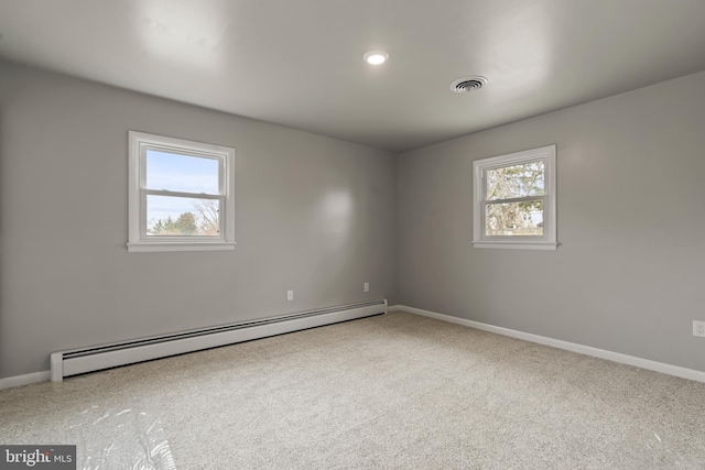 spare room with a baseboard radiator, baseboards, carpet, and visible vents