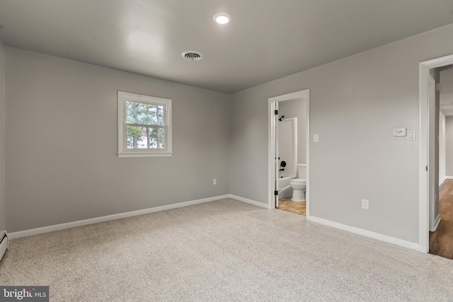 unfurnished bedroom with visible vents, connected bathroom, baseboards, and carpet