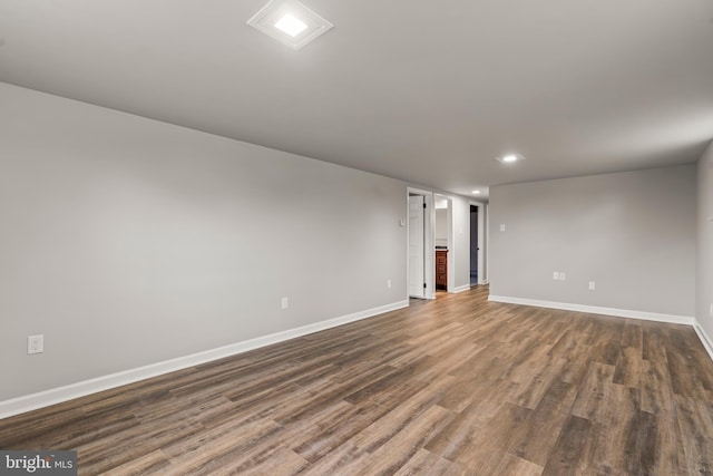 unfurnished room with dark wood finished floors, recessed lighting, and baseboards