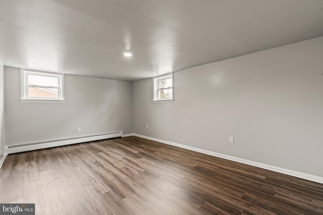 basement featuring baseboards, baseboard heating, and wood finished floors