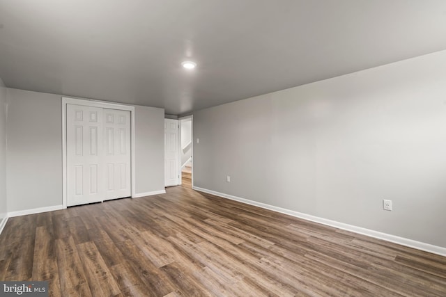 unfurnished bedroom featuring a closet, baseboards, and wood finished floors