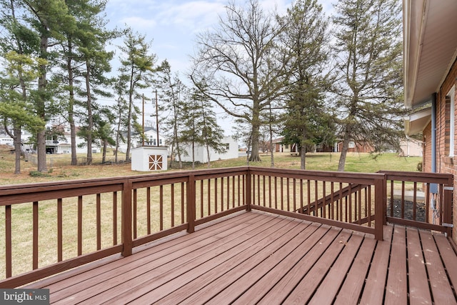 deck with a yard, an outbuilding, a storage shed, and fence