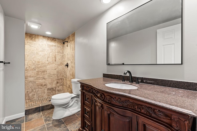 full bathroom featuring toilet, stone finish flooring, a tile shower, recessed lighting, and vanity