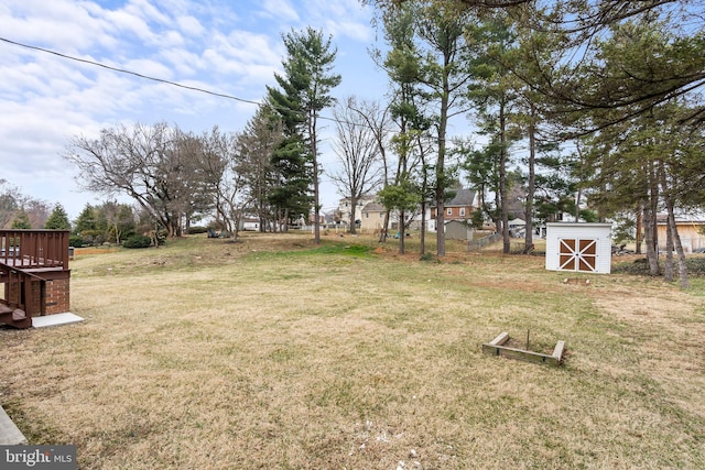 view of yard with an outdoor structure, a storage unit, and fence