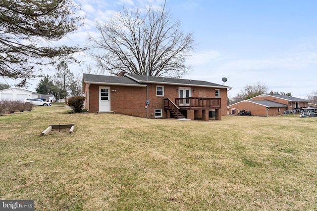 back of house with brick siding, a lawn, and a deck