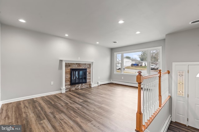 unfurnished living room featuring visible vents, wood finished floors, recessed lighting, a stone fireplace, and baseboards