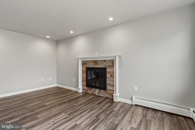 unfurnished living room with wood finished floors, baseboards, a baseboard radiator, a fireplace, and recessed lighting