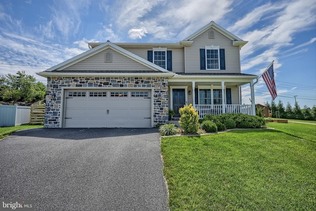 traditional-style house featuring a front lawn, driveway, stone siding, a porch, and fence