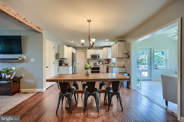 dining room with a notable chandelier, recessed lighting, baseboards, and wood finished floors