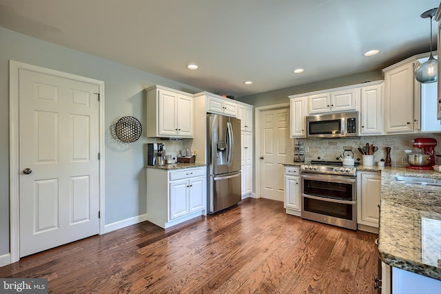 kitchen featuring tasteful backsplash, appliances with stainless steel finishes, dark wood-style floors, and white cabinetry