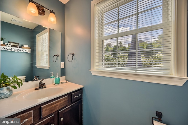 bathroom with visible vents, toilet, and vanity