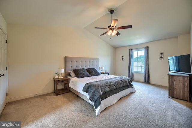 carpeted bedroom with vaulted ceiling, a ceiling fan, and baseboards