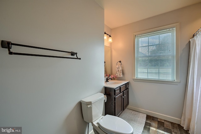 full bath featuring vanity, toilet, and baseboards