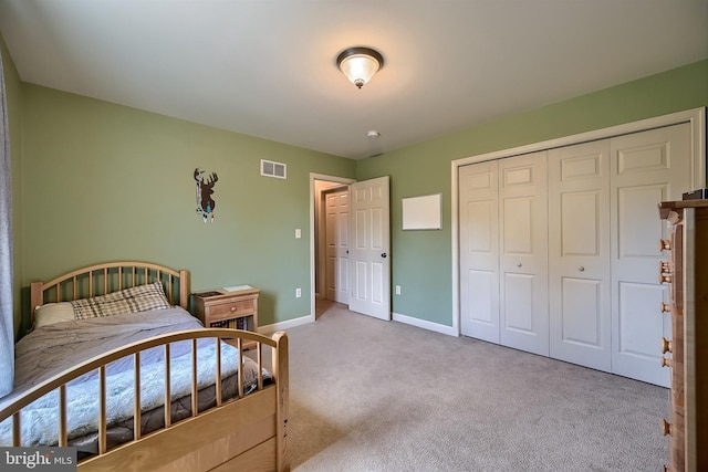 carpeted bedroom with baseboards, visible vents, and a closet