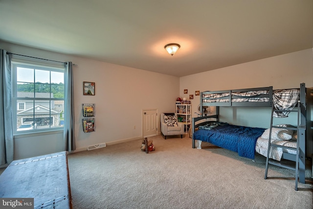 carpeted bedroom featuring baseboards and visible vents